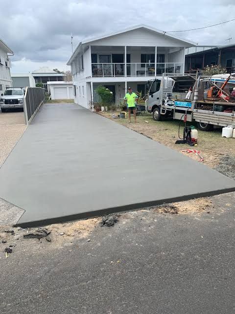 A freshly poured driveway at a Woodgate home, with one of the crew and the work truck